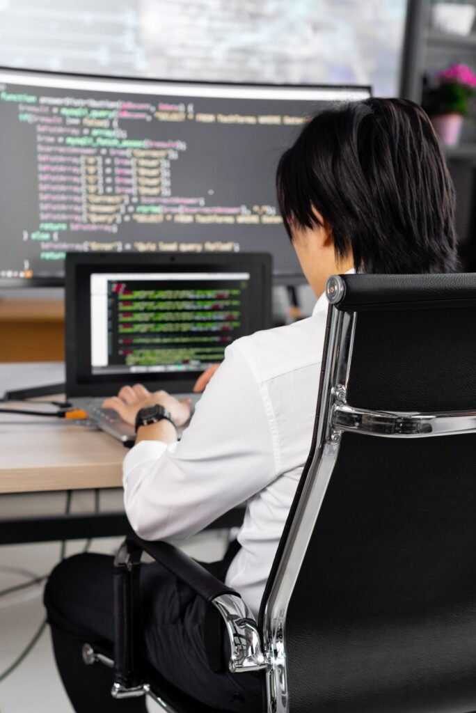Developer reviewing website code on dual monitors during a technical SEO audit