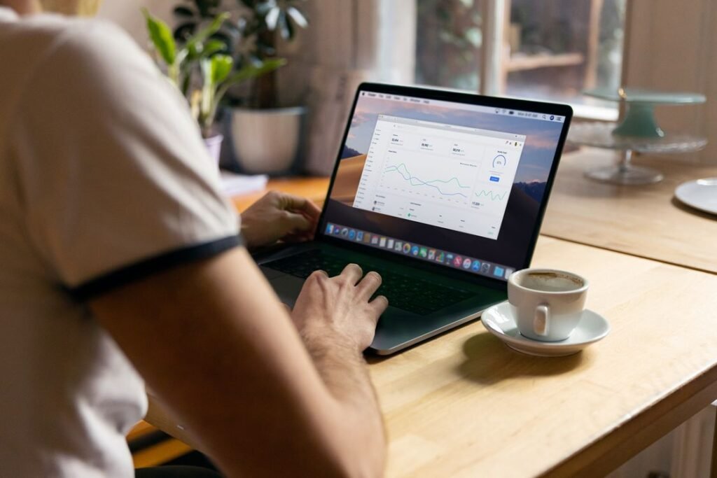 Person working on a laptop with analytics on screen in a cozy home office