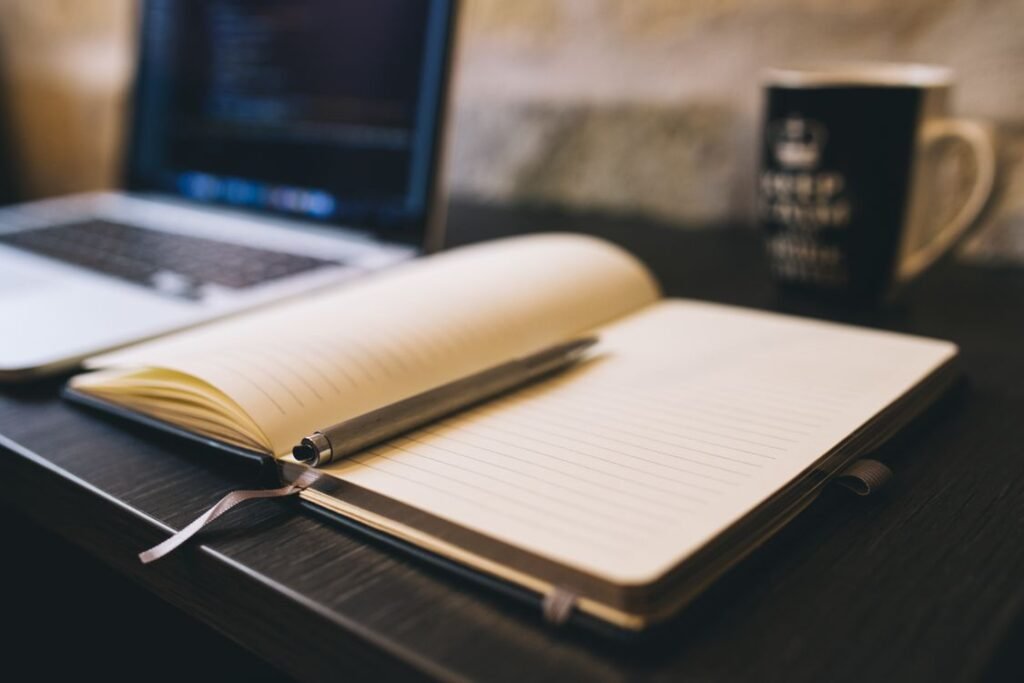 Open notebook with pen beside a laptop showing how to update old blog posts for SEO with a content refresh